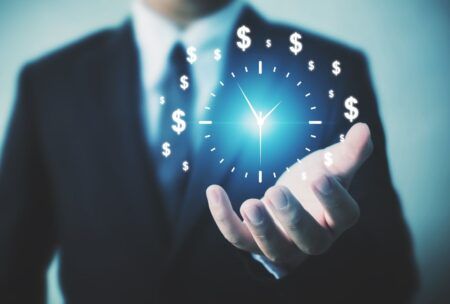 businessman holding a clock adorned with dollar signs, symbolizing time management hacks for financial success