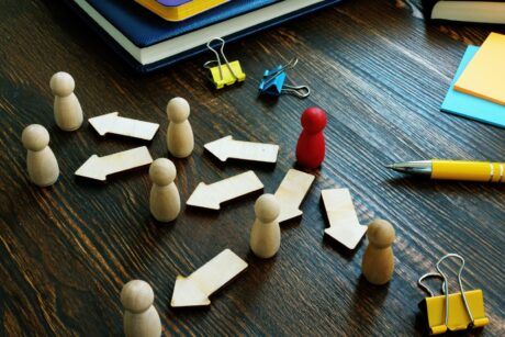 a wooden board featuring wooden figures and arrows, illustrating delegation training for managers