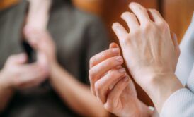 a woman places one hand against the other, illustrating a concept from eft training
