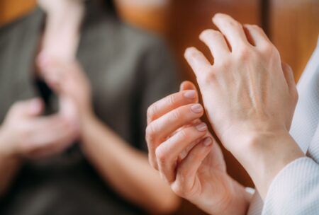 a woman places one hand against the other, illustrating a concept from eft training