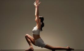 a woman in a white top is engaged in a yoga pose for her hatha yoga online training class