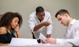 a man points at a woman and another man during a stress management class meeting
