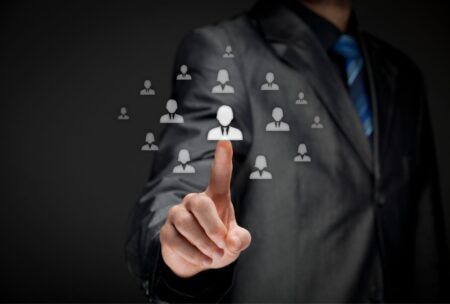 businessman pointing to icons of diverse people, illustrating effective HR practices in a corporate setting