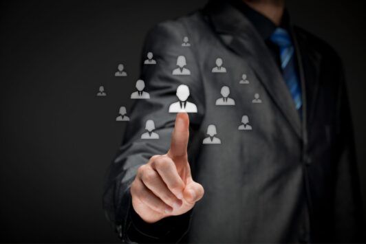 businessman pointing to icons of diverse people, illustrating effective HR practices in a corporate setting