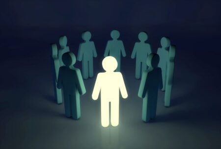 a person stands confidently in a circle of people, embodying an innovative mindset and fostering collaboration