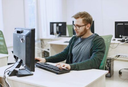 a man at a desk uses a computer to learn laravel development techniques