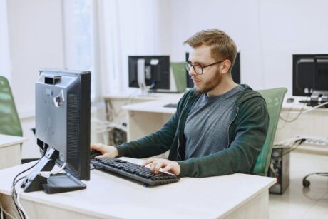 a man at a desk uses a computer to learn laravel development techniques
