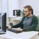 a man at a desk uses a computer to learn laravel development techniques