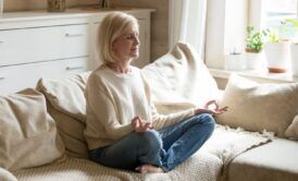 a woman practicing mindfulness meditation on a couch during a mindfulness course