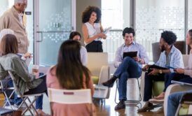 a group of people seated in chairs during a facilitation course in a meeting room